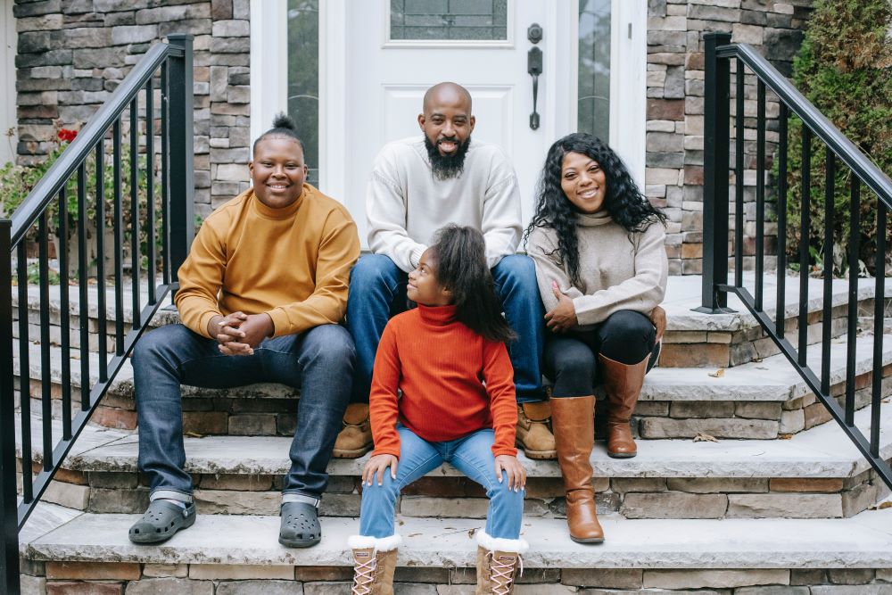 Family sitting on step in their home